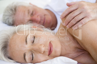 Couple lying in bed together sleeping