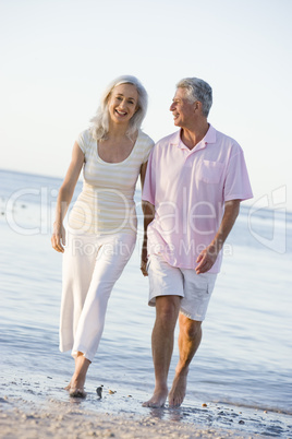 Couple at the beach holding hands and smiling