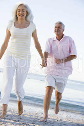 Couple at the beach holding hands and smiling