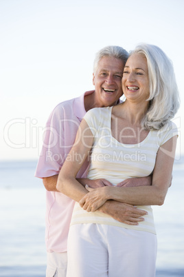 Couple at the beach embracing and smiling