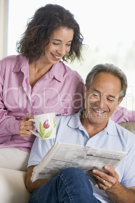 Couple relaxing with a newspaper smiling