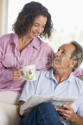 Couple relaxing with a newspaper smiling