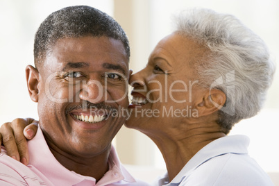 Couple relaxing indoors kissing and smiling