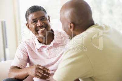 Two men in living room talking and smiling