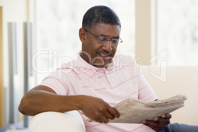 Man relaxing with a newspaper smiling