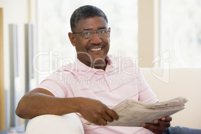 Man relaxing with a newspaper smiling