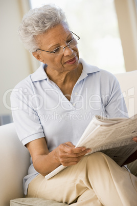 Woman relaxing with a newspaper smiling