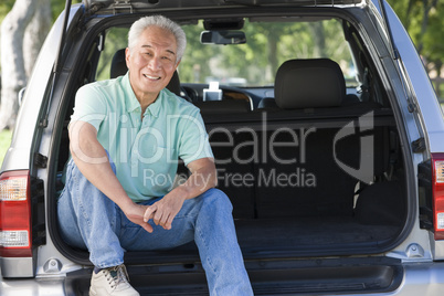 Man sitting in back of van smiling
