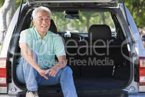 Man sitting in back of van smiling