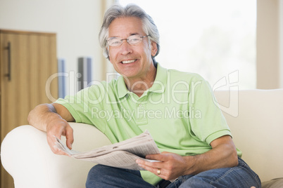 Man relaxing with a newspaper smiling