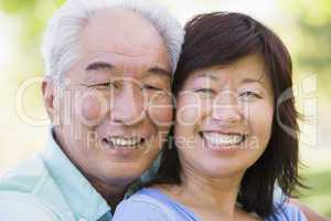 Couple relaxing outdoors in park smiling