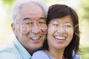 Couple relaxing outdoors in park laughing