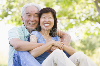 Couple relaxing outdoors in park smiling