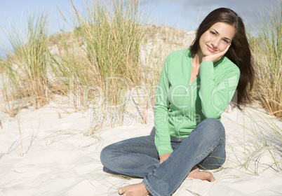 Young woman relaxing amongst dunes