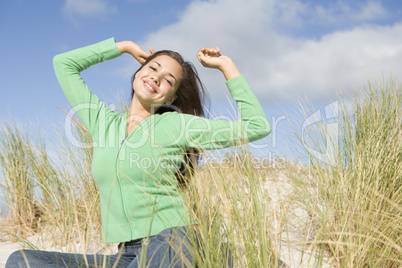 Young woman stretching in dunes