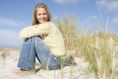 Young woman sitting amongst dunes