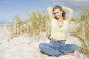 Young woman relaxing amongst dunes