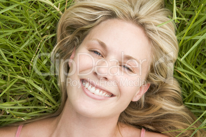 Overhead view of young woman lying on grass