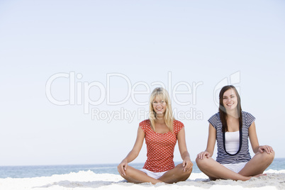 Two women sitting on beach
