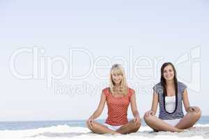Two women sitting on beach