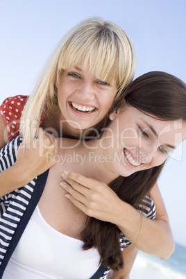 Two female friends embracing on beach