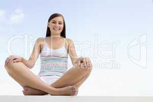 Woman sitting cross legged outside