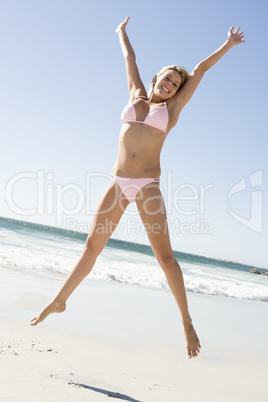 Young woman jumping on beach