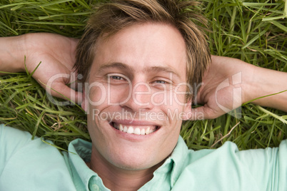 Man lying on grass smiling