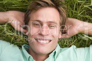 Man lying on grass smiling