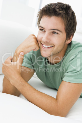 Man lying in living room smiling