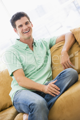 Man sitting in living room laughing