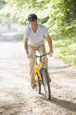 Man outdoors riding bike smiling