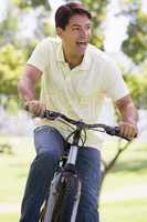 Man outdoors riding bike smiling