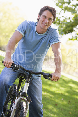 Man outdoors on bike smiling