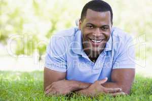 Man lying outdoors smiling