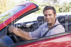 Man in convertible car smiling