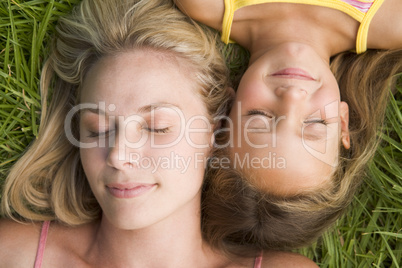 Woman and young girl lying in grass sleeping