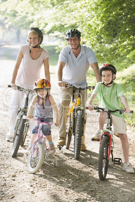 Family sitting on bikes on path smiling