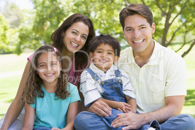 Family sitting outdoors smiling