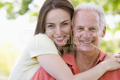 Man and woman outdoors embracing and smiling