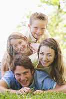 Family lying outdoors smiling