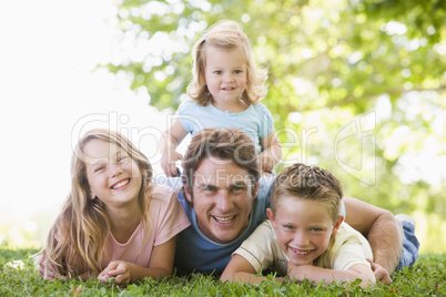 Family lying outdoors smiling Family lying outdoors smiling