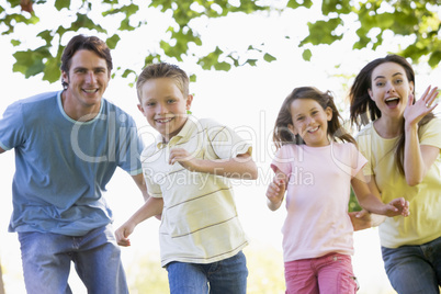 Family running outdoors smiling