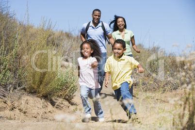 Family running on path smiling