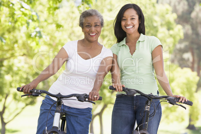 Two women on bikes outdoors smiling