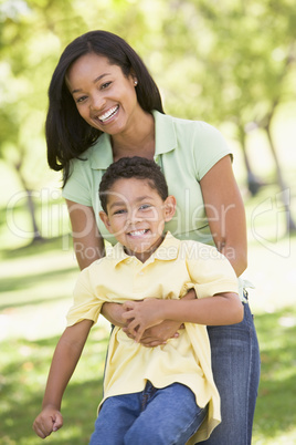 Woman and young boy outdoors embracing and smiling