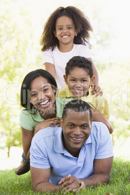 Family lying outdoors smiling