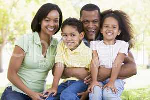 Family sitting outdoors smiling