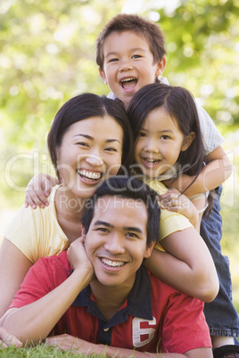 Family lying outdoors smiling