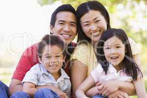 Family sitting outdoors smiling